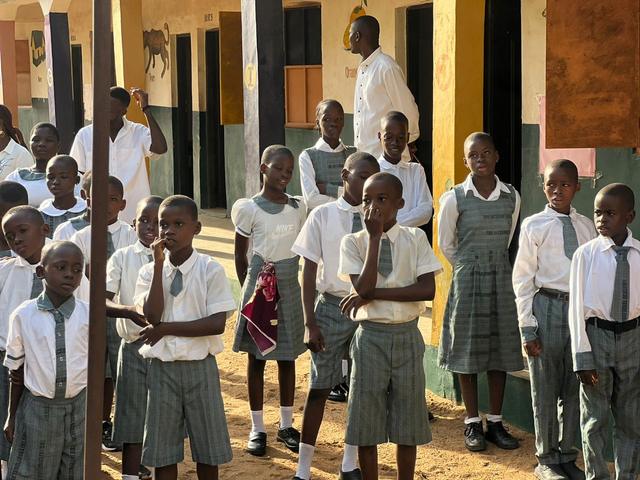 Basic pupils in the green check uniform waiting in line at the start of the school day