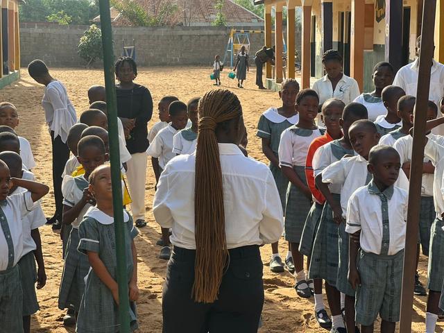 A teacher addressing pupils at morning assembly on the TBD International Academy compound